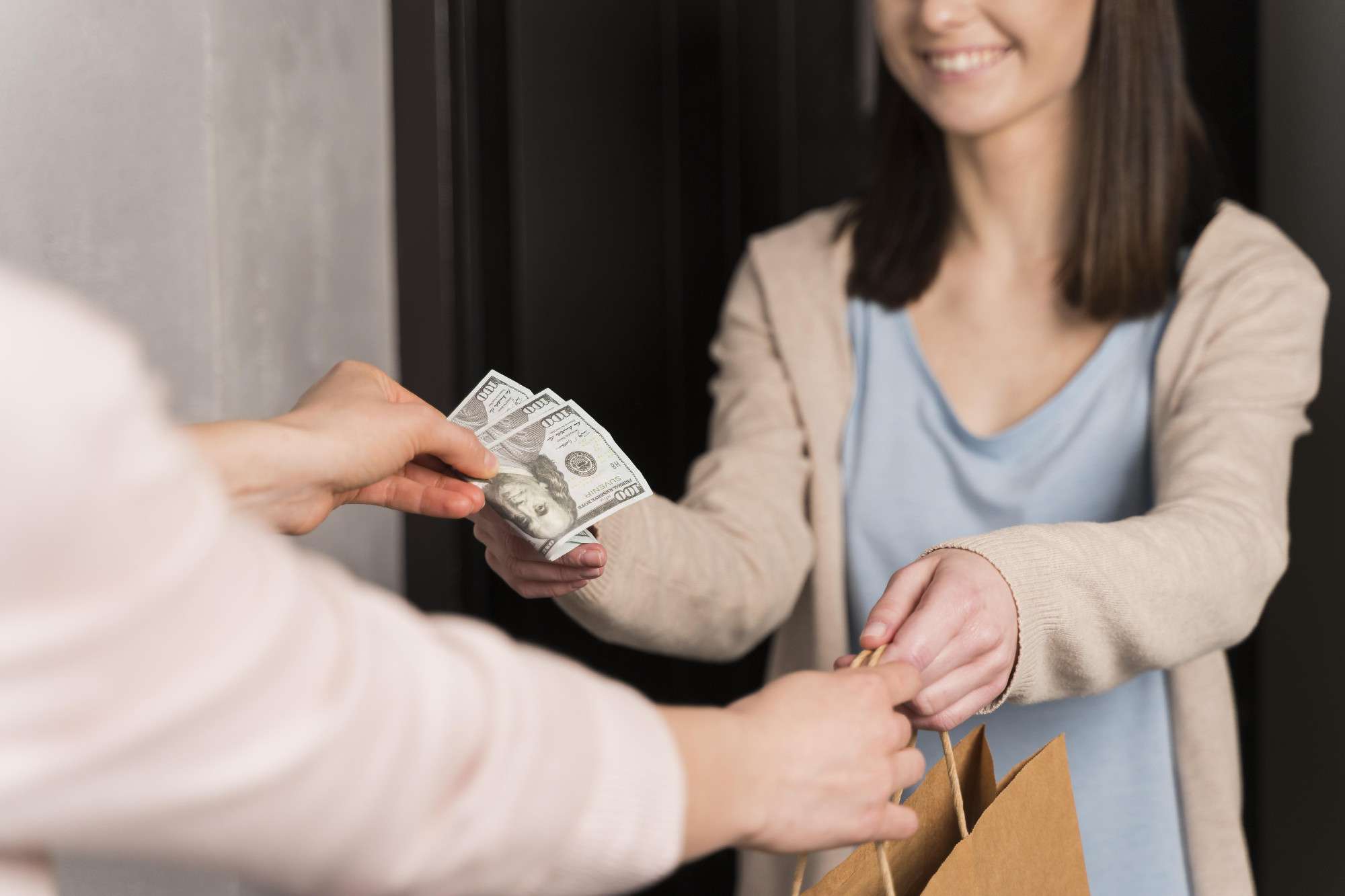 woman-delivering-paper-bag-receiving-banknotes.jpg