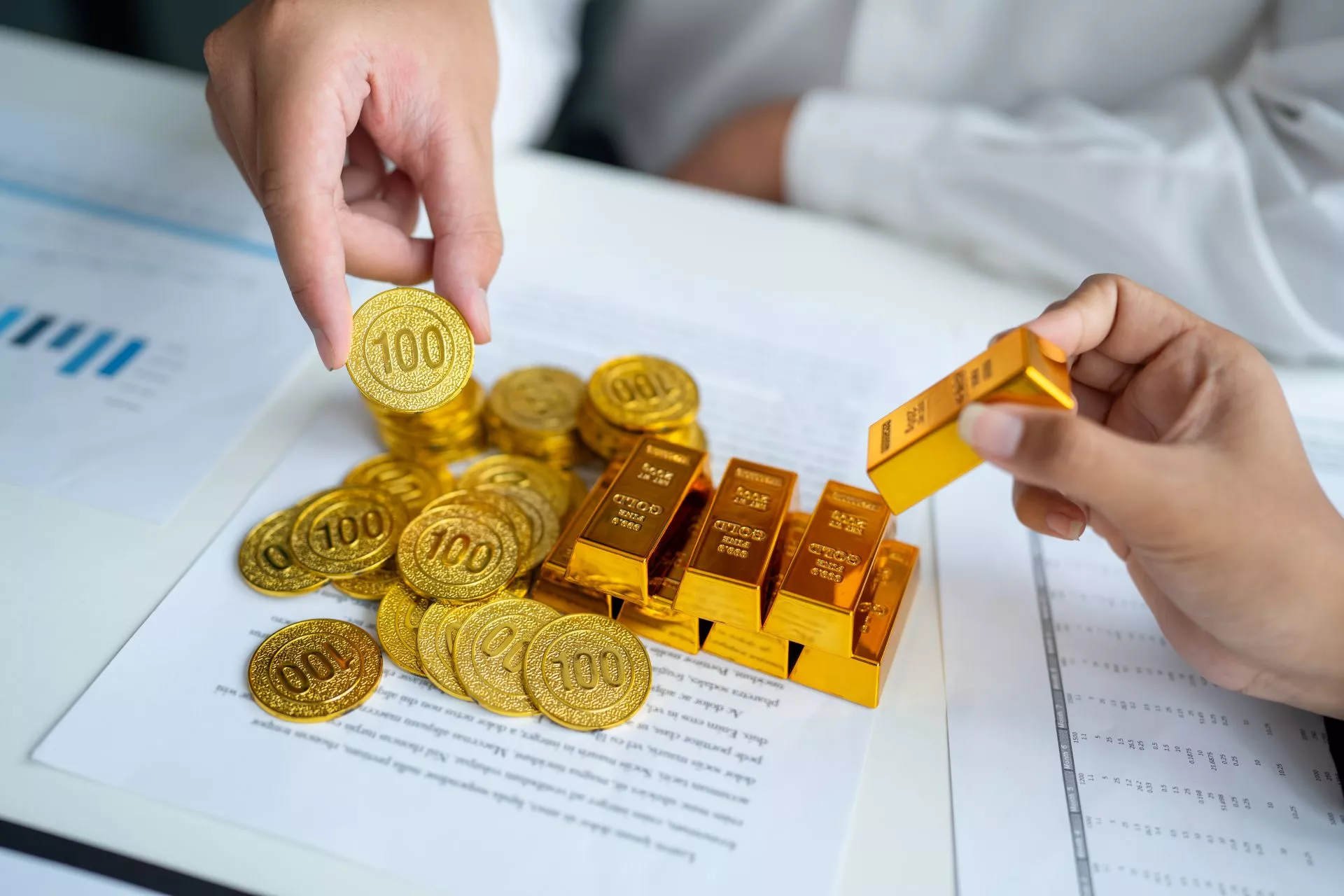 202607145263.webp 雙手正在檢視金條與金幣,呈現台中黃金典當、黃金估價、金價波動、重量成色確認與當鋪借款週轉情境。