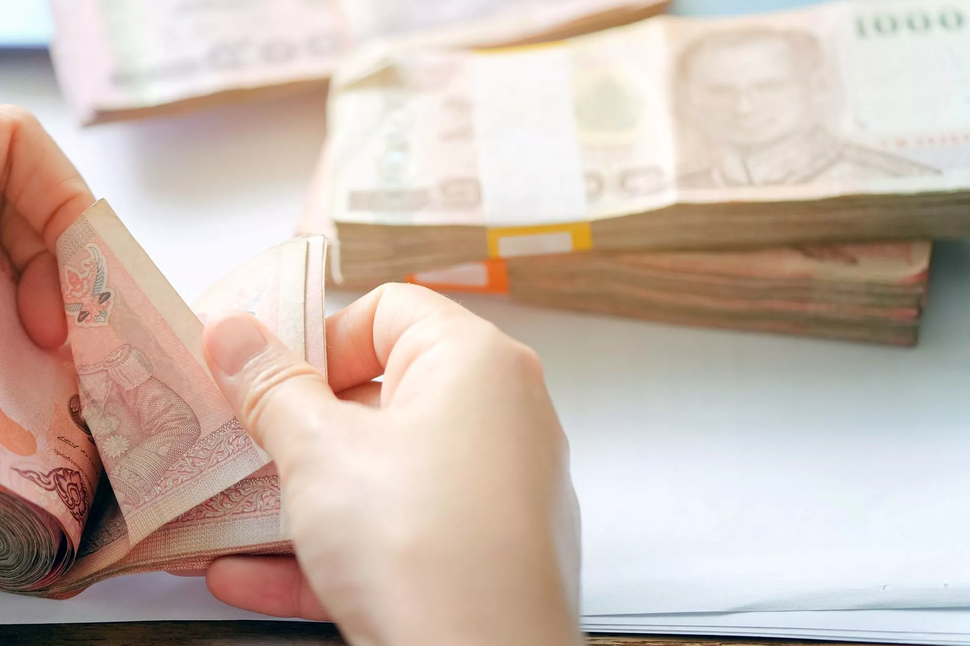 雙手正在清點新台幣現金，呈現台中當鋪借款、台中借款申請、假借款廣告防詐、資金週轉與借款安全確認情境。
